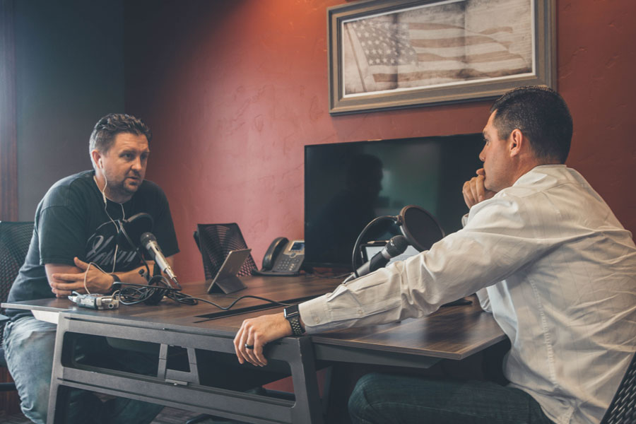 Zwei Männer führen ein Gespräch und zeichnen es in einem Podcasting auf.